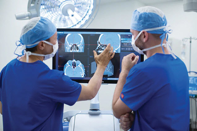 Surgeons observing digital images on large screen