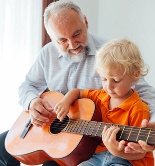 Grandfather with child playing guitar
